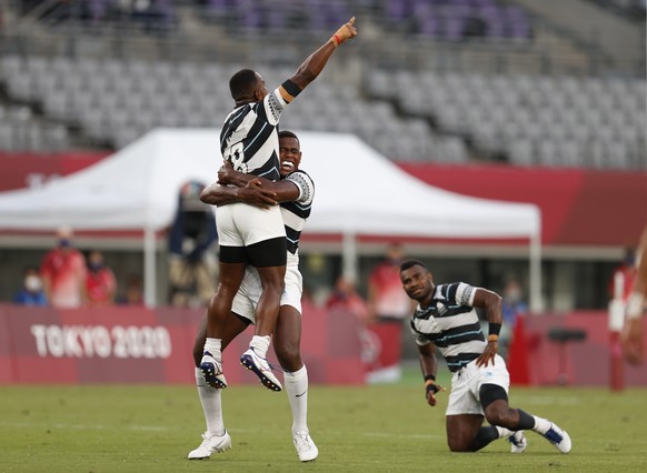 epa09373216 Players from Fiji react after defeating New Zealand during the Rugby Sevens Men&#039;s Gold Medal match between New Zealand and Fiji at the Tokyo 2020 Olympic Games at the Tokyo Stadium in ...