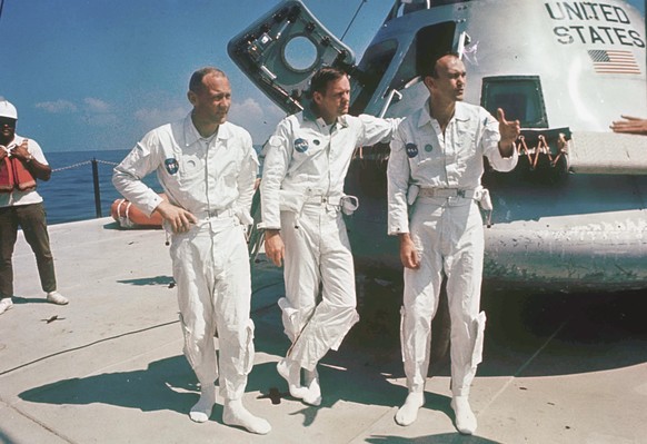 FILE - Apollo 11 astronauts Col. Edwin E. Aldrin, left, lunar module pilot, Neil Armstrong, center, flight commander, and Lt. Michael Collins, right, command module pilot, stand next to their spacecra ...