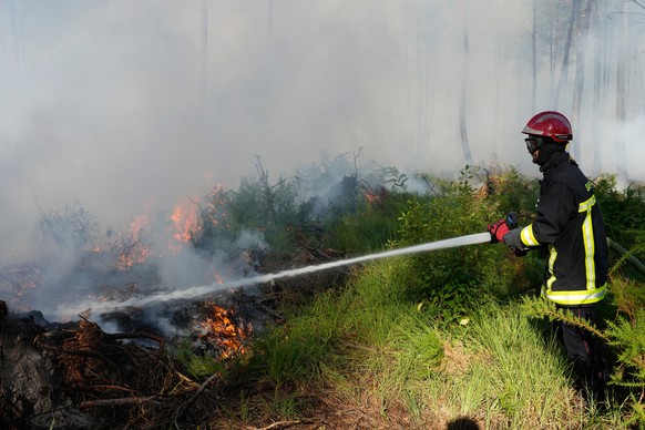 A firefighter works to suppress flames near Lacanau, as wildfires rage outside Bordeaux, France, Monday, July 27, 2026. (AP Photo/Baz Ratner)
France Wildfires