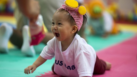 epa04338516 A child crawls on a mat during a baby crawling contest in Hong Kong, China, 02 August 2014. The contest is part of the 22nd International Baby/Children Products Expo which runs until 04 Au ...
