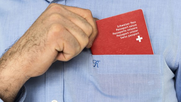 Ein Mann hat einen biometrischen Schweizer Pass in der Brusttasche seines Hemdes, aufgenommen am 10. Februar 2014 in Bern. (KEYSTONE/Christian Beutler)