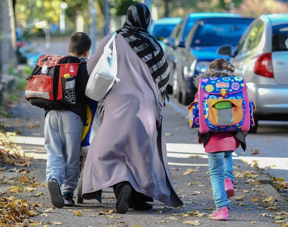 Eine Muslima mit Kopftuch holt in Freiburg ihre Kinder nach Unterrichtsschlusss von der Schule ab. Foto:Winfried Rothermel *** a Muslim with Headscarf picks in Freiburg theirs Children after from the  ...