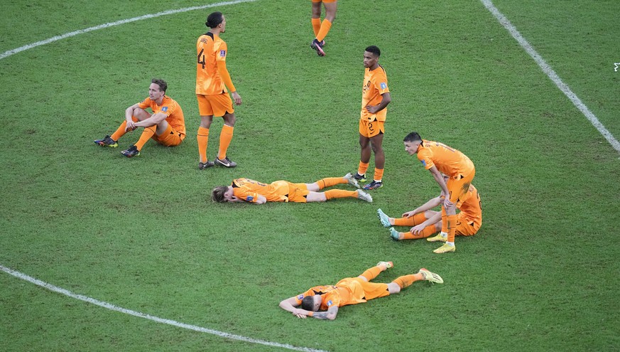 Netherlands players pause on the pitch at the end of the World Cup quarterfinal soccer match between the Netherlands and Argentina, at the Lusail Stadium in Lusail, Qatar, Saturday, Dec. 10, 2022. (AP ...