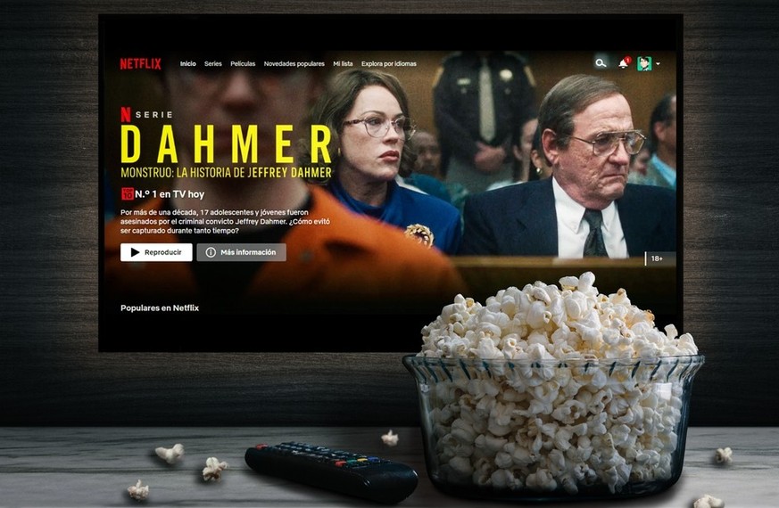 Netflix-App auf TV-Bildschirm mit dem Titel &quot;Dahmer Monster: Die Jeffrey Dahmer Geschichte &quot; hinter einer Schüssel Popcorn und einer Fernbedienung.