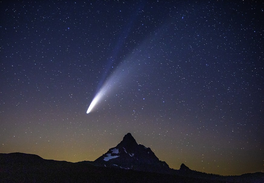 Comet Neowise appears over Mount Washington in the night sky as seen from Dee Wright Observatory on McKenzie Pass east of Springfield, Ore., Tuesday, July 14, 2020. According to NASA the lower tail, w ...