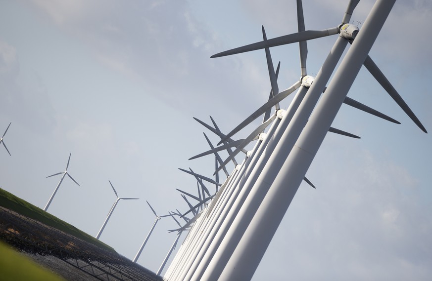 Wind turbines are seen on a dike near Urk, Netherlands, Friday, Jan. 22, 2021. A group of scientists, including five Nobel laureates, called Friday for more action to adapt the world to the effects of ...