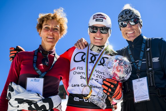 Lara Gut-Behrami of Switzerland winner of the women&#039;s super-g overall leader crystal globe trophy pose with mother Gabriella and father Pauli in the finish area at the FIS Alpine Skiing World Cup ...