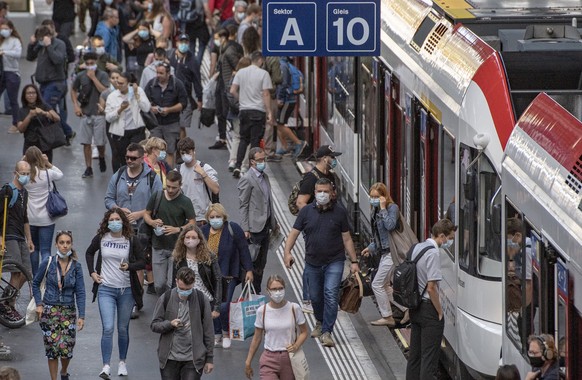 Die Zugsreisenden verlassen einen Zug mit Schutzmasken waehrend der Corona-Pandemie am Montag, 6. Juli2020 im Bahnhof Luzern. (KEYSTONE/Urs Flueeler).