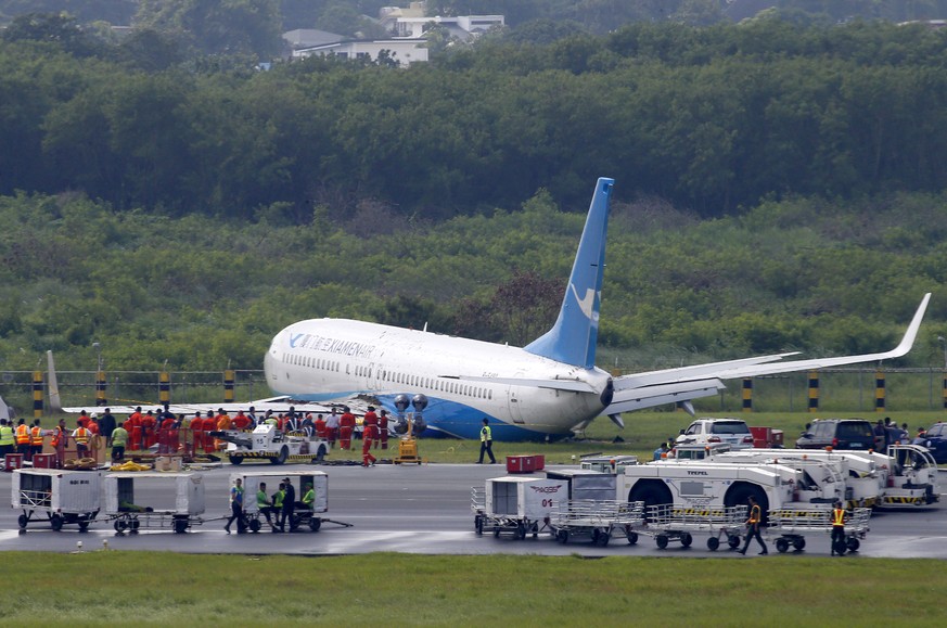 A Boeing passenger plane from China, a Xiamen Air, sits on the grassy portion of the runway of the Ninoy Aquino International Airport after it skidded off the runway while landing Friday, Aug. 17, 201 ...