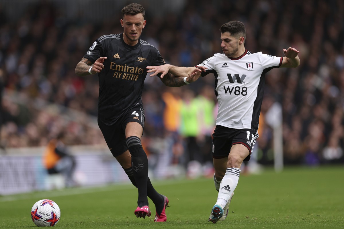 Arsenal's Ben White, left, duels for the ball with Fulham's Manor Solomon during the English Premier League soccer match between Fulham and Arsenal at Craven Cottage stadium in London, Sunda ...