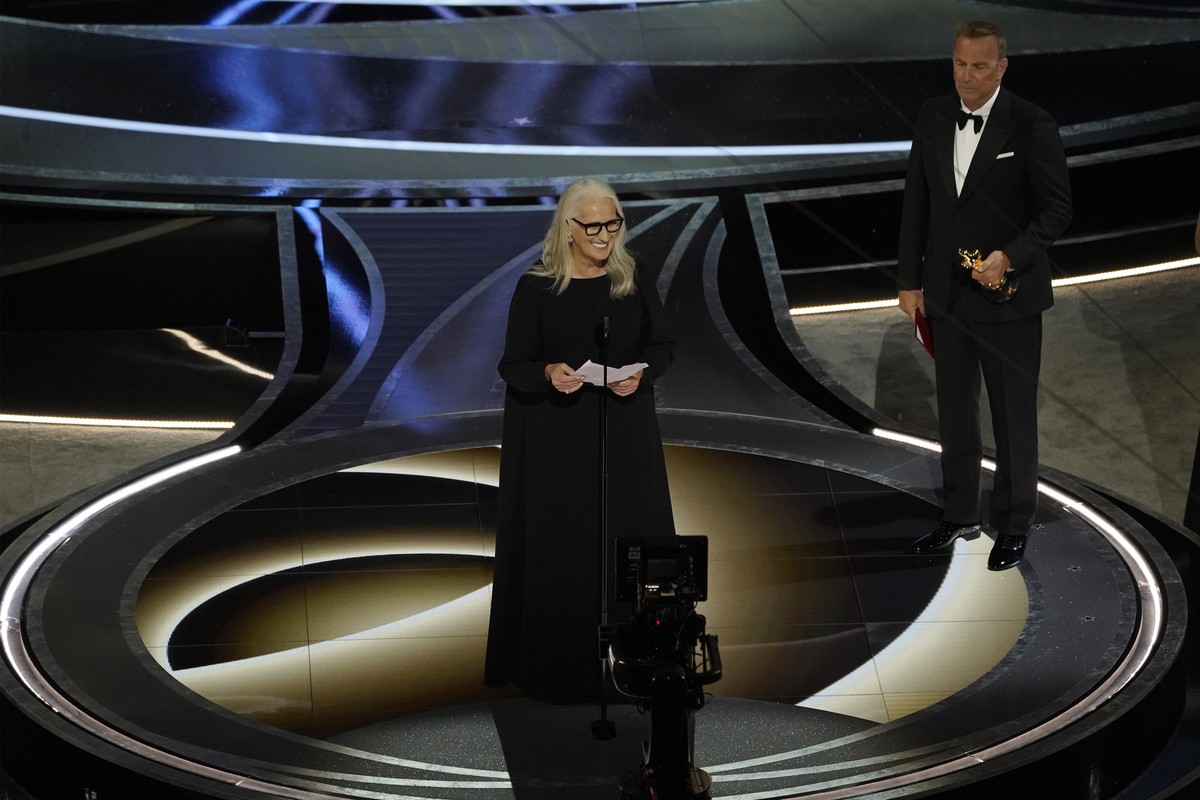 Jane Campion, center, accepts the award for best director for "The Power of the Dog" while Kevin Costner looks on from right at the Oscars on Sunday, March 27, 2022, at the Dolby Theatre in  ...