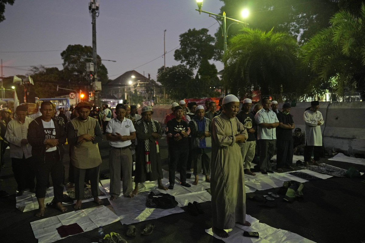 Protesters pray during a rally alleging a widespread fraud in the Feb. 14 presidential election, ahead of the announcement of the election results, outside the General Election Commission's offic ...