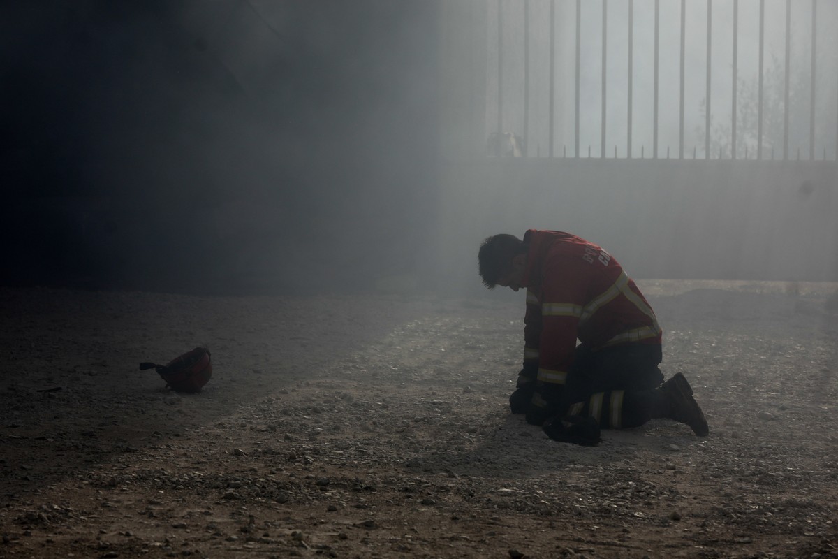 epaselect epa06268200 A firefighter kneels on the ground during a fire in Vila Nova de Poiares, Lousa, Portugal, 15 October 2017. The National Civil Protection Authority (ANPC) said it 'was the w ...