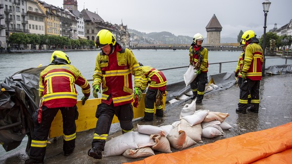 Die Feuerwehr der Stadt Luzern sichert die Bahnhofstrasse entlang der Reuss mit Schutzschlaeuchen aufgrund der angekuendigten Regenfaelle der naechsten Tage, am Dienstag, 13. Juli 2021, in Luzern. Der ...