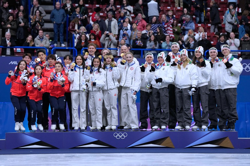 From left to right, silver medalists Team Japan, gold medalists Team USA and bronze medalists Team Italy receive their medals after the figure skating team event at the 2026 Winter Olympics, in Milan, ...