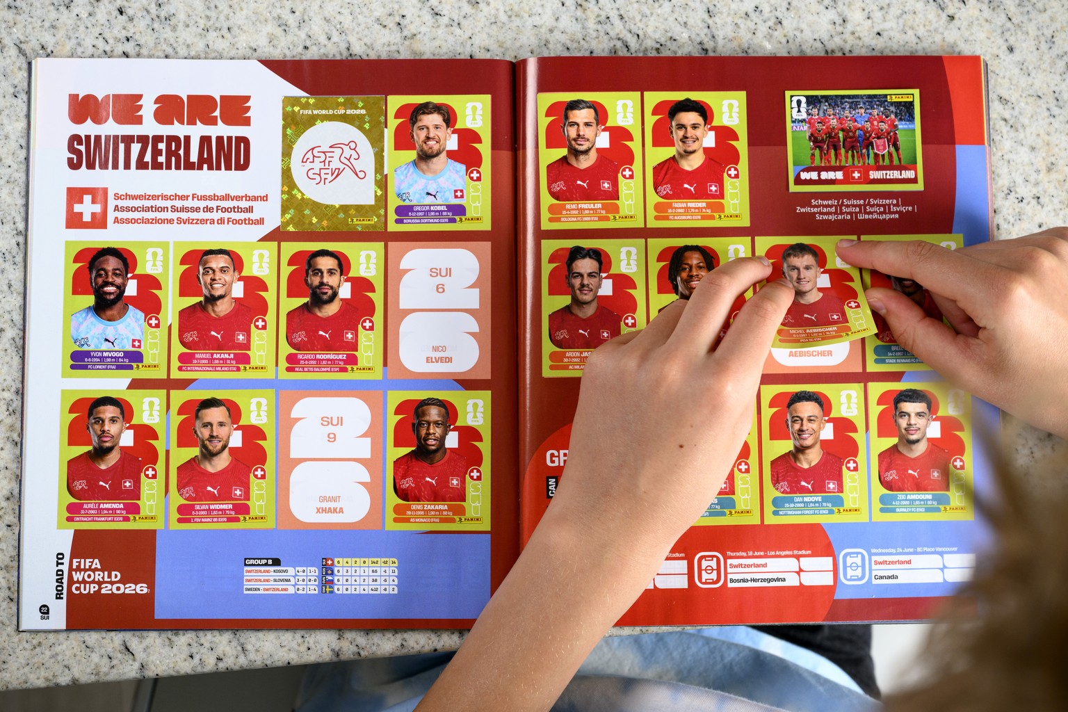 A young collector sticks a Panini World Cup sticker of the Switzerland's soccer national team in the official panini album of the 2026 FIFA World Cup USA Canada Mexico, in Lausanne, Switzerland,  ...