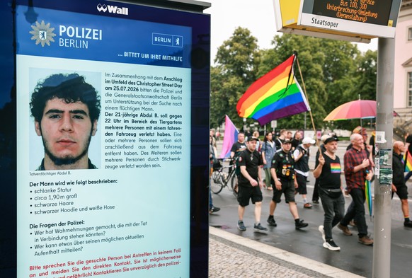epa13134272 People attending a mourning march following a car-ramming attack near the Christopher Street Day (CSD) parade route pass an electronic display showing a police appeal for information about ...