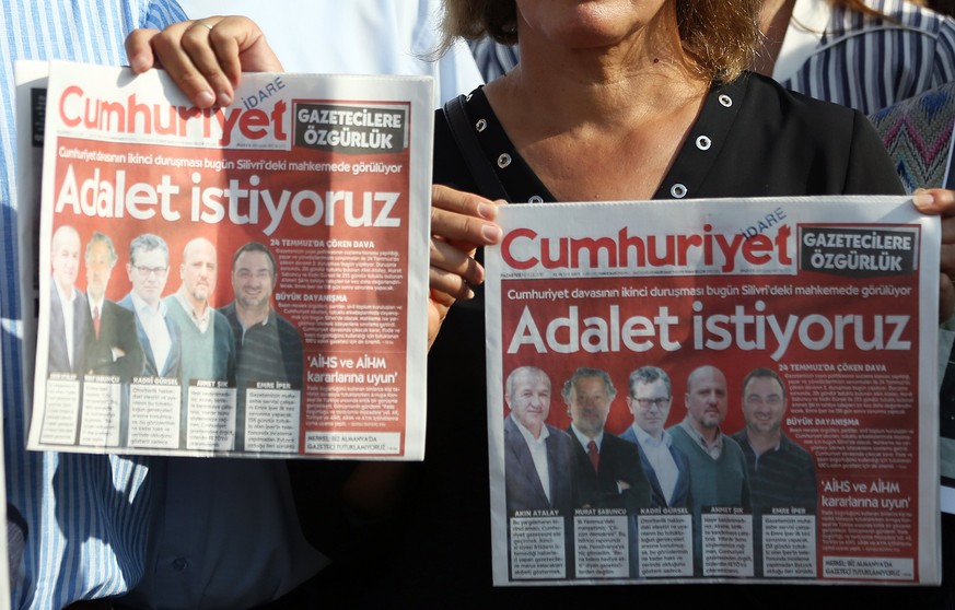 epaselect epa06197765 People hold copies of the current Cumhuriyet newspaper&#039;s edition in front of the Silivri Prison during a trial against staff of Cumhuriyet newspaper in Istanbul, Turkey, 11  ...