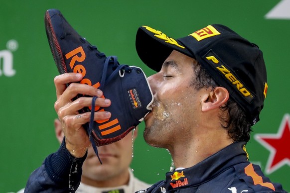 epa06670459 Australian Formula One driver Daniel Ricciardo of Aston Martin Red Bull Racing drinks champagne out of his shoe on the podium after winning the Chinese Formula One Grand Prix at the Shangh ...