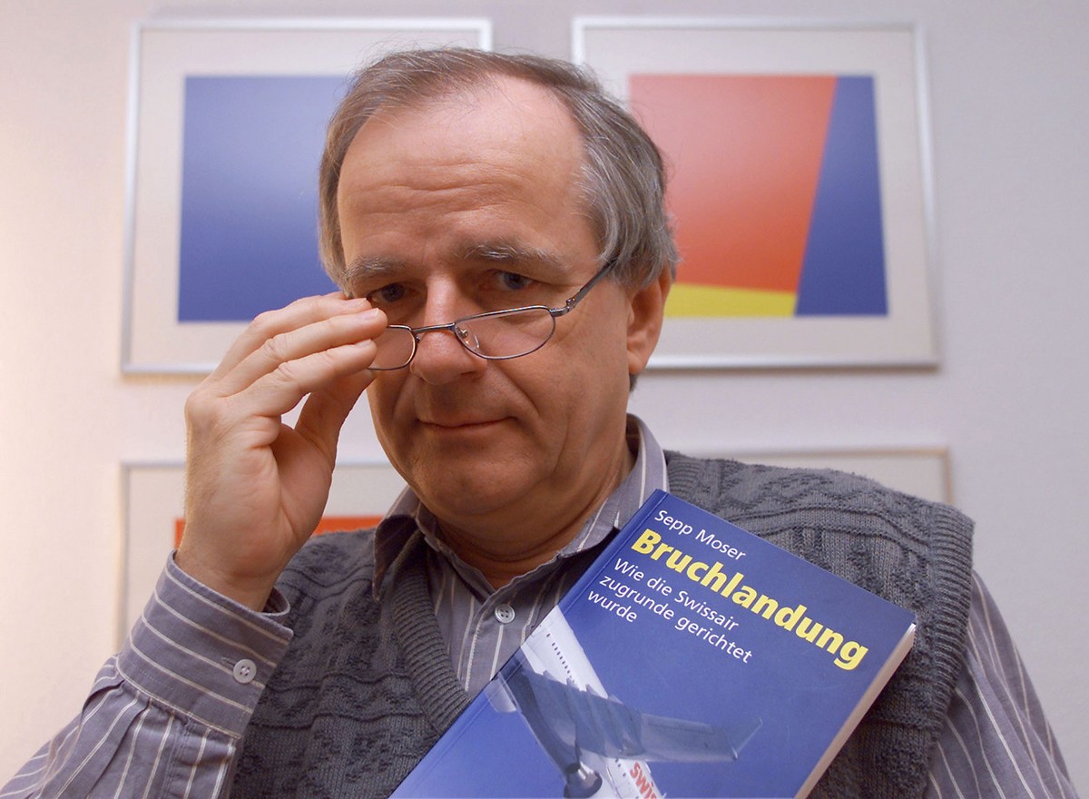 Aviatikexperte und Publizist Sepp Moser posiert am Dienstag, 4. Dezember 2001, in Winkel ZH mit seinem Buch "Bruchlandung - Wie die Swissair zugrunde gerichtet wurde", das dieser Tage erschi ...