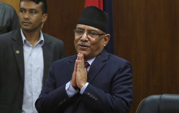 FILE- Leader of communist party Nepal, Pushpa Kamal Dahal greets the gathering after announcing his resignation as prime minister, in line with an agreement made with his coalition partner party, in K ...