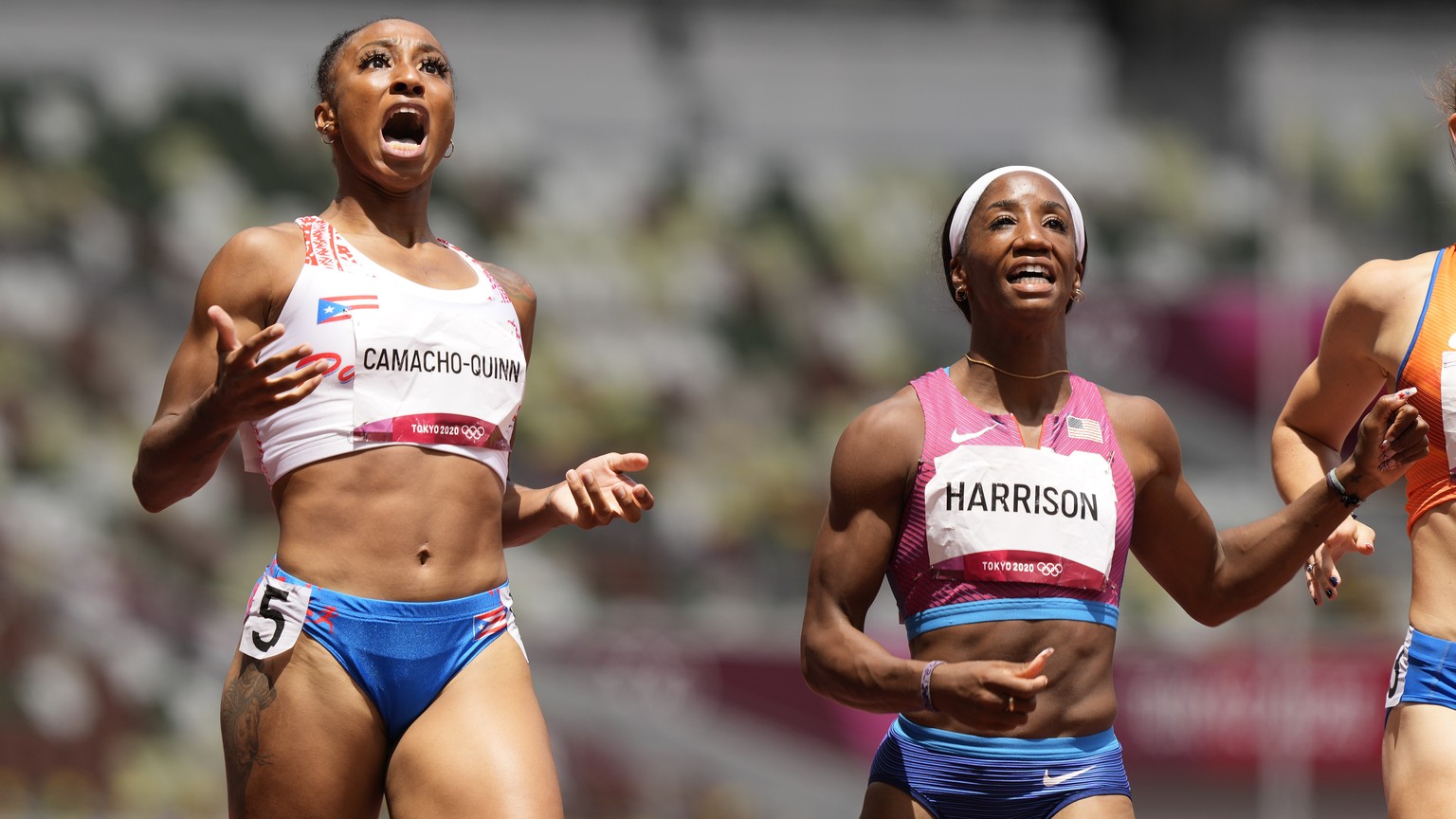 Jasmine Camacho-Quinn, of Puerto Rico, left, celebrates after winning the gold in the women&#039;s 100-meters hurdles final ahead of Kendra Harrison, of United States, silver, at the 2020 Summer Olymp ...