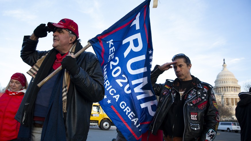 epa08925405 Trump supporters salute at a makeshift monument at the West Front of the US Capitol, for Ashli Babbitt, who was shot and died the day before during a mob riot of Trump supporters at the US ...