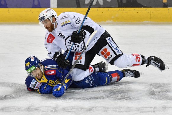 Lugano&#039;s Riccardo Werder, oben, drueckt den Davoser Lorenz Kienzle zu Boden, waehrend dem Eishockey-Qualifikationsspiel der National League zwischen dem HC Davos und dem HC Lugano, am Samstag, 27 ...