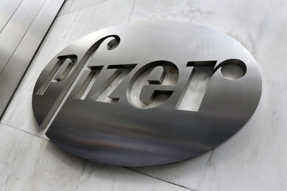 FILE - This Dec. 4, 2017, photo shows the Pfizer company logo at the company&#039;s headquarters in New York. Higher medicine sales helped the drug giant swing to a small profit in the fourth-quarter, ...