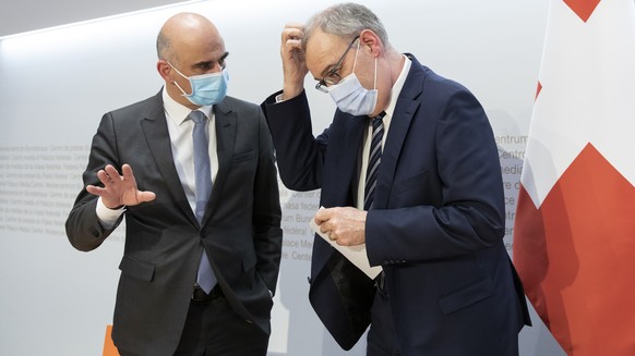 Bundespraesident Guy Parmelin, rechts, diskutiert mit Bundesrat Alain Berset am Ende einer Medienkonferenz des Bundesrates zur aktuellen Lage im Zusammenhang mit dem Coronavirus, am Mittwoch, 24. Febr ...