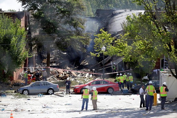 Fire fighters look through the debris of a four-story building that was destroyed in an explosion that has left up to seven people missing in Silver Spring, Maryland, U.S., August 11, 2016. REUTERS/Jo ...