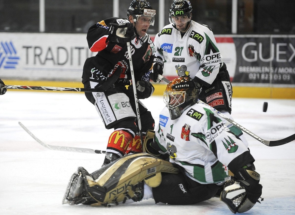 Tim Smith, gauche du LHC marque le 3eme but lausannois face a Patrick Bloch, centre et au gardien Urban Leimbacher, droite de Olten lors du match de National League B, LNB, du championnat suisse de ho ...