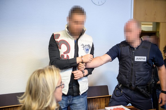 epa06799947 Defendant Christian L. (C) arrives for his trial on charges related to sexual abuse of a minor at the regional court in Freiburg, Germany, 11 June 2018. Christian L. and Berrin T. are accu ...
