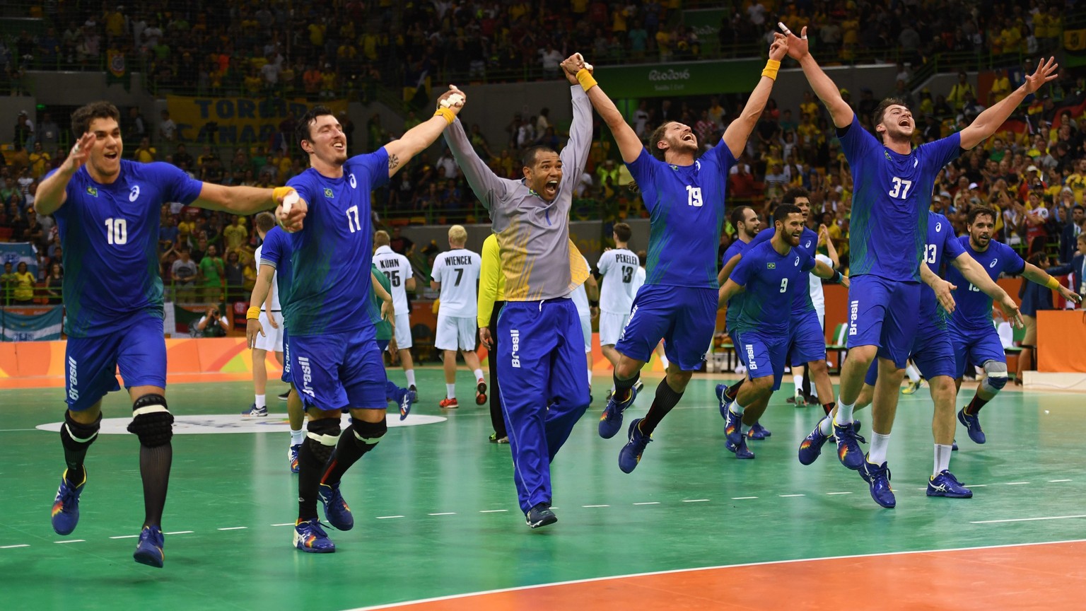 epa05475261 Players of Brazil celebrate with supporters their win after the men&#039;s preliminary round match between Brazil and Germany for the Rio 2016 Olympic Games handball tournament at the Futu ...