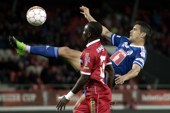 Le joueur valaisan Chadrac Akolo, gauche, lutte pour le ballon avec le joueur lucernois Ricardo Costa, droite, lors de la rencontre de demi-finale de la Coupe Suisse de football entre le FC Sion et le ...