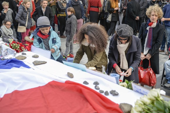 Menschen gedenken den Opfern des Terroranschlags in Paris beim Zuercher Opernhaus am Sonntag, 15. November 2015. (KEYSTONE/Walter Bieri)

People pay tribute to the victims of the Paris Attacks, in f ...