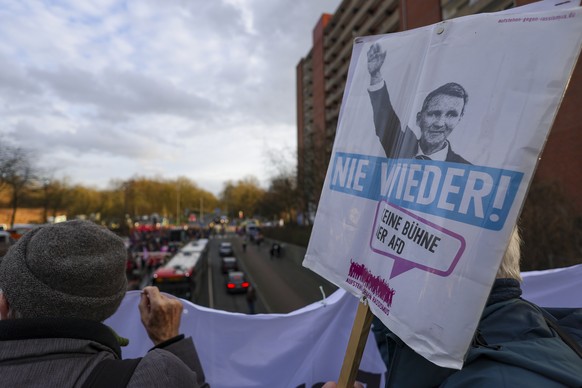 epa12771835 People hold a placard depicting Bjoern Hoecke and reading 'never again - no stage for AFD' is seen during a protest against an event organized by the AFD party to which AfD facti ...