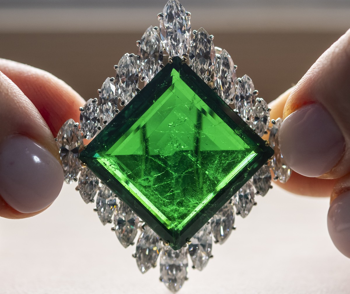 epa11707942 A Christie's employee displays the Aga Khan Emerald, a Cartier emerald and diamond brooch, 1960, a square-shaped of 37.00 carats, marquise-shaped diamonds, platinum and 18k yellow gol ...