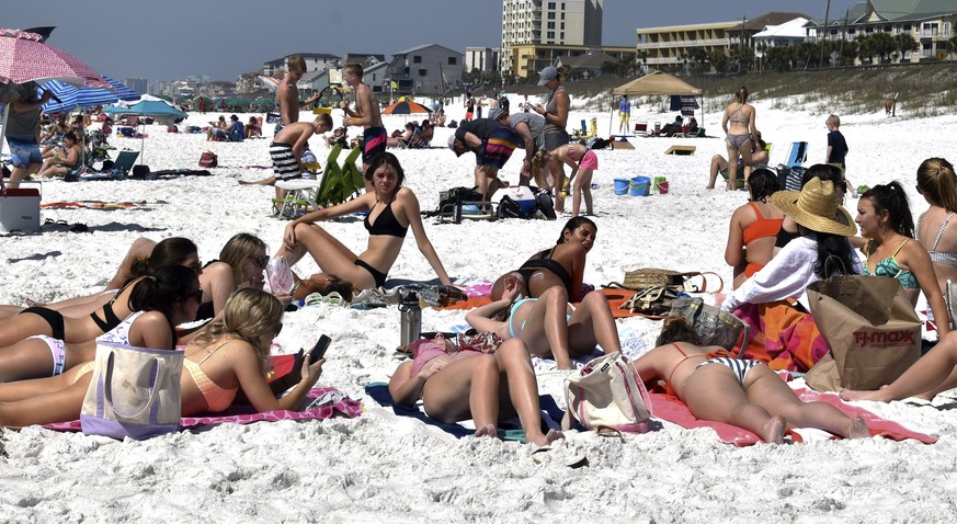 Students from Clemson University lie on the beach during spring break near Pompano Joe&#039;s Restaurant in Miramar Beach near Destin, Fla., on Monday, March 16, 2020. Speaking about the coronavirus,  ...