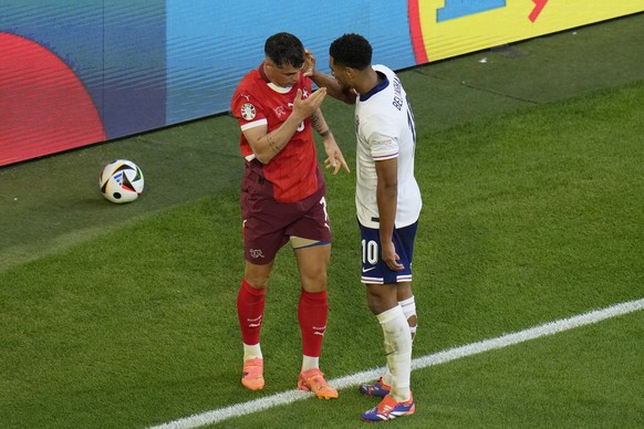 England's Jude Bellingham, right, speaks with Switzerland's Granit Xhaka after a challenge during a quarterfinal match between England and Switzerland at the Euro 2024 soccer tournament in D ...
