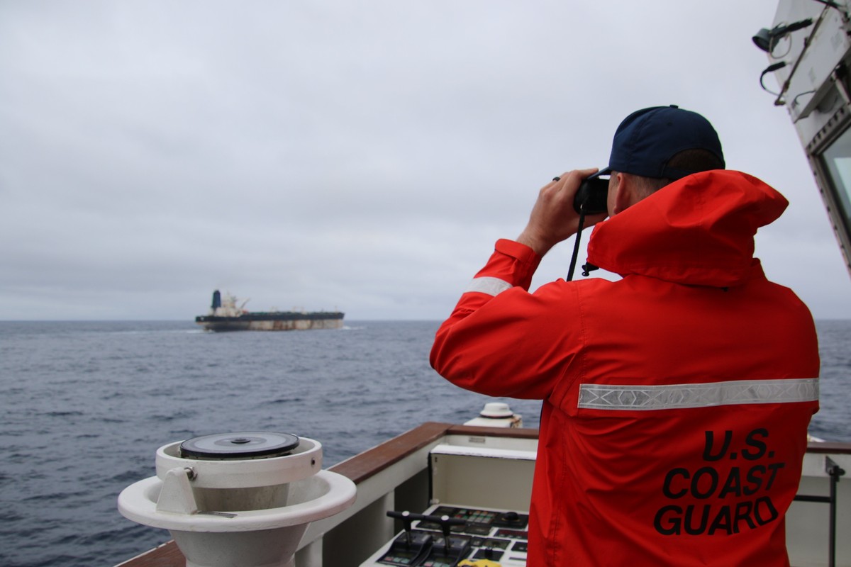 epa12634146 An undated handout photo made available by the US European Command (EUCOM)'s X account on 07 January 2026 shows a US Coast Guard official looking through binoculars as the ship Marine ...