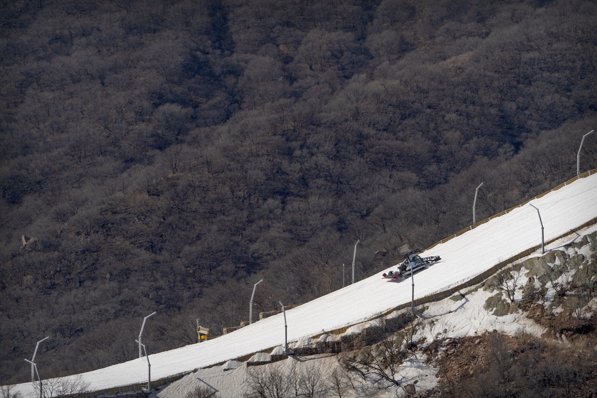 A machine grooms a ski run lined with artificial snow at the National Alpine Skiing Center in Yanqing on the outskirts of Beijing, Friday, Feb. 5, 2021. Beijing Olympic organizers showed off the downh ...