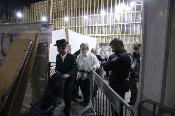 Ultra-Orthodox Jewish men leave a synagogue in Givat Zeev, outside Jerusalem, Sunday, May 16, 2021. Israeli medics say more than 150 people were injured in a fatal collapse of a bleacher at an uncompl ...