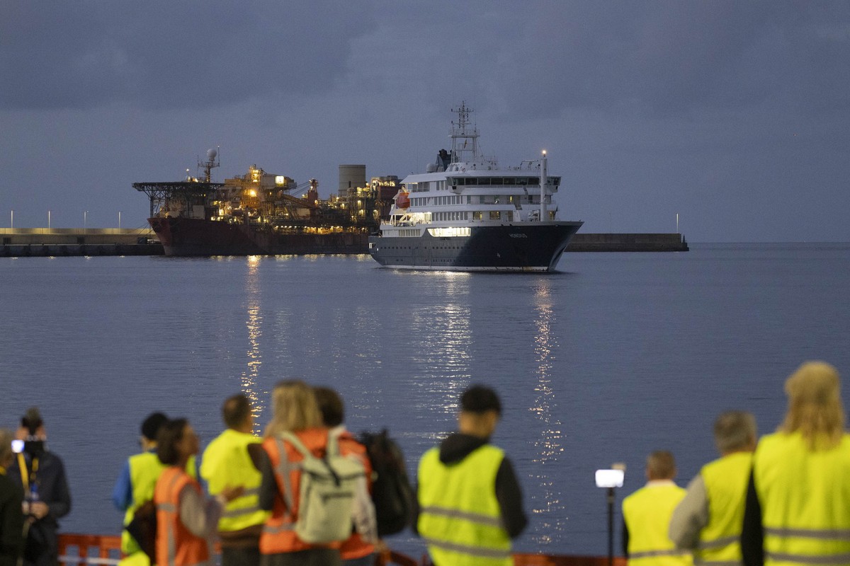 epaselect epa12944930 Media crews stand to cover the arrival of the Dutch-flagged vessel MV Hondius (R), affected by a hantavirus outbreak during its voyage across the South Atlantic, as it enters the ...