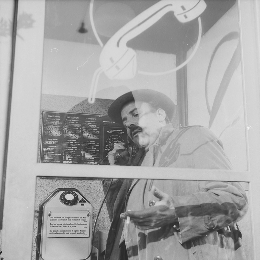 Die Eisen-Glas-Telefonkabinen der Nachkriegszeit werden nach und nach mit durchsichtigem Glas und neuem Logo ausgestattet. Der Akt des Telefonierens findet jetzt in der Öffentlichkeit statt. Natürlich durfte dabei auch geraucht werden!