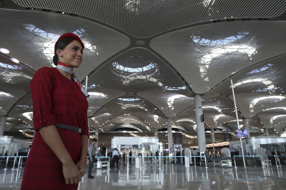 An airline employee stands in Istanbul's new airport ahead of its opening, Monday Oct. 29, 2018. Turkey's President Recep Tayyip Erdogan is set to inaugurate Istanbul's new airport, sla ...