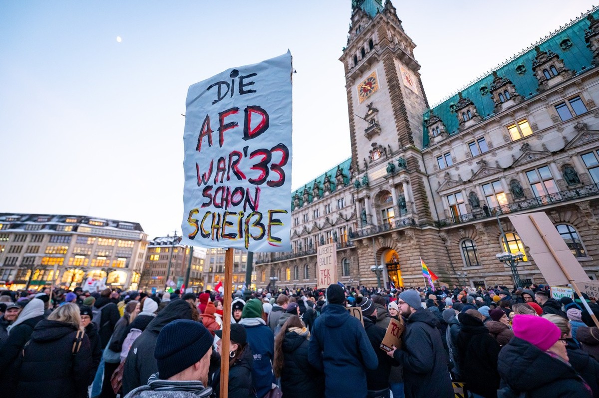 19.01.2024, Hamburg: "Die AfD war' 33 schon Scheiße" steht auf einem Schild vor dem Rathaus bei einer Demonstration. Mit der Demonstration wollen die Teilnehmenden ein Zeichen des Wider ...