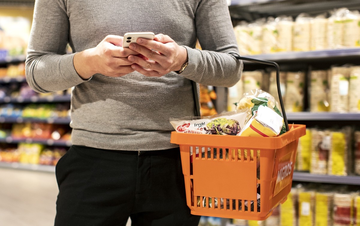 Freiwilligenhelfer Niccolo Brunetti erledigt einen Einkauf via der "Amigos-App" in der Migros am Limmatplatz, am Freitag, 17. April 2020, in Zuerich. Die Migros und Pro Senectute bieten mit  ...