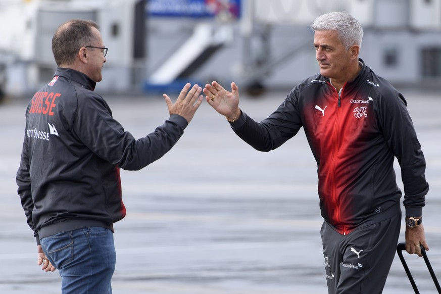 Switzerland&#039;s national soccer team head coach Vladimir Petkovic, right, cheers with chief press officer of the Swiss soccer federation Marco Von Ah, left, after getting off the Swiss Internationa ...