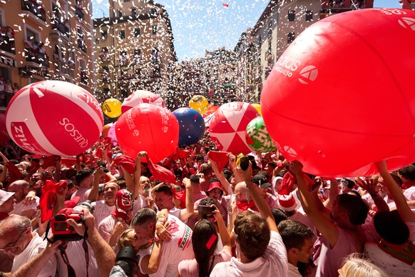 Revelers celebrate as the txupinazo, the traditional rocket marking the start of the San Fermín festival, kicks off nine days of uninterrupted festivities in Pamplona, Spain, Monday, July 6, 2026. (AP ...